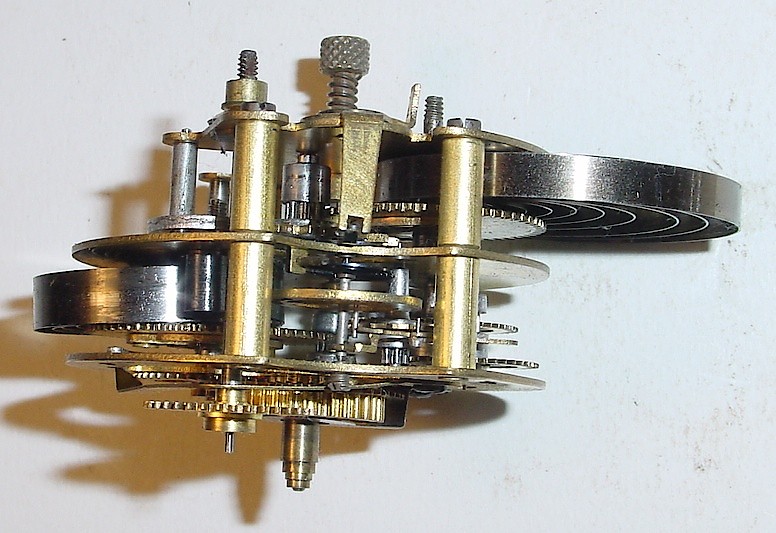 Westclox Baby Ben 2 Inch. Side view of the "two layer" movement used in the Baby Ben Two Inch. The layer nearest the dial is the timekeeping portion and is the 2 inch time-only movement commonly used in novelty and desk clocks. The rear layer of the movement contains the alarm mechanism.

Photo courtesy of Gary Biolchini