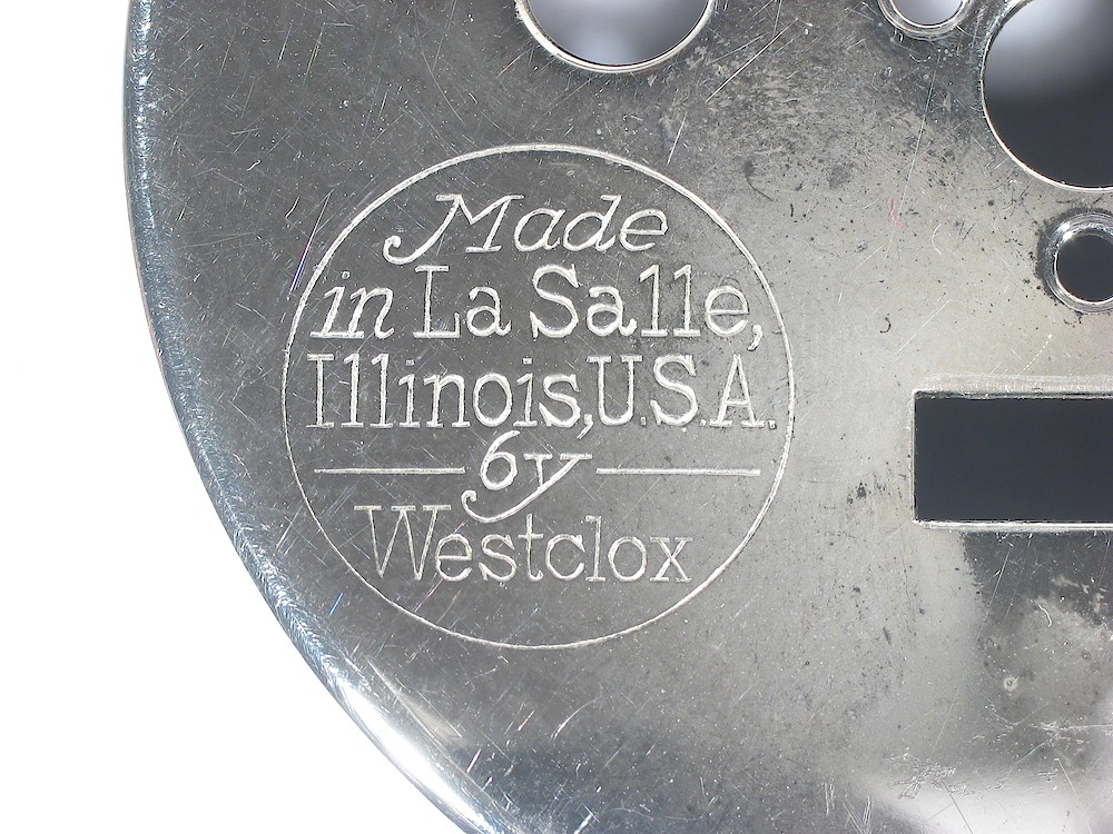 Westclox Big Face Baby Ben Style 1 Prototype. This logo was used on some Big Ben from 1914 - 1916 Made
in La Salle, 
Illinois, USA
--- by --- 
Westclox

This logo is 11/16 inch diameter. 

The logo on the Big Ben is 7/8 inch diameter. This logo was also used on the Sleepmeter and Sleepmeter Intermittent and was 11/16 inch diameter.