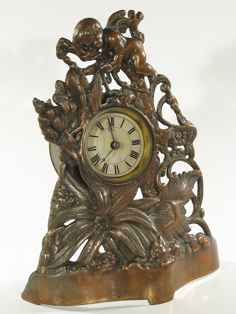 Golden Novelty Cherub And Flowers Cast Front. Golden Novelty Cherub And Flowers Cast Front Clock Example Photo