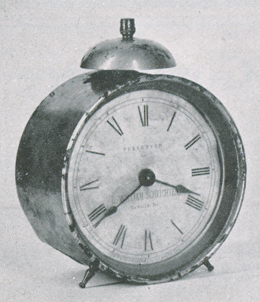 Westclox Tick Talk, January 20, 1928 (Factory Edition), Vol. 13 No. 14 > 5-cropped. Historical Picture (closeup): Early Westclox 4 Inch Alarm Clock. Dial Says: PRESENTED BY G.WILLIAM SCHLICHTEN, La Salle, Ill. (a Local Merchant).