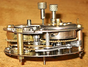 Westclox Baby Ben Style 1 Non Luminous. Mainspring barrels. Alarm "going barrel" on the left. Time "winding barrel" on the right. The time barrel has the normal type of punched curved mainspring hook