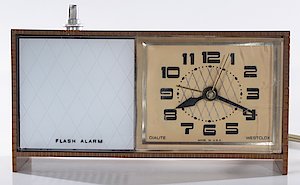 Westclox Moonbeam Style 3 Flashalarm Woodgrain. Modified by Nationwide Flashing Signal Systems, Inc., 8120 Fenton St., Silver Spring, MD 20910. They added an outlet on the back and a push switch on top. There are two modes. 1) internal light and light plugged into the outlet flash off and on at the alarm time. 2) The internal light and light plugged into the outlet are on continuously (night light mode).