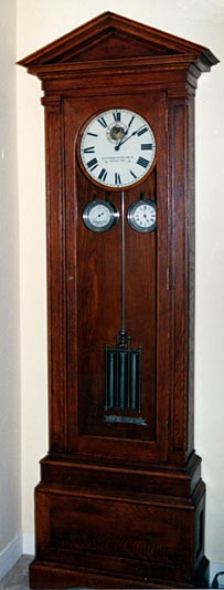 Standing type master clock in one of several pediment-style cases built during the early 20th century